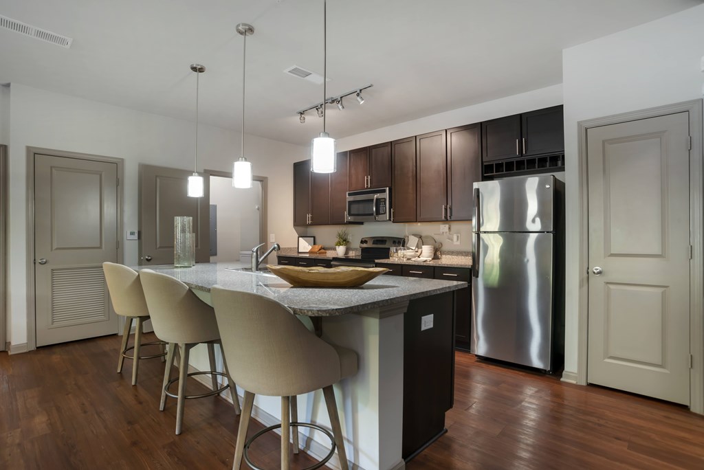A modern kitchen with a large island and stainless steel appliances.